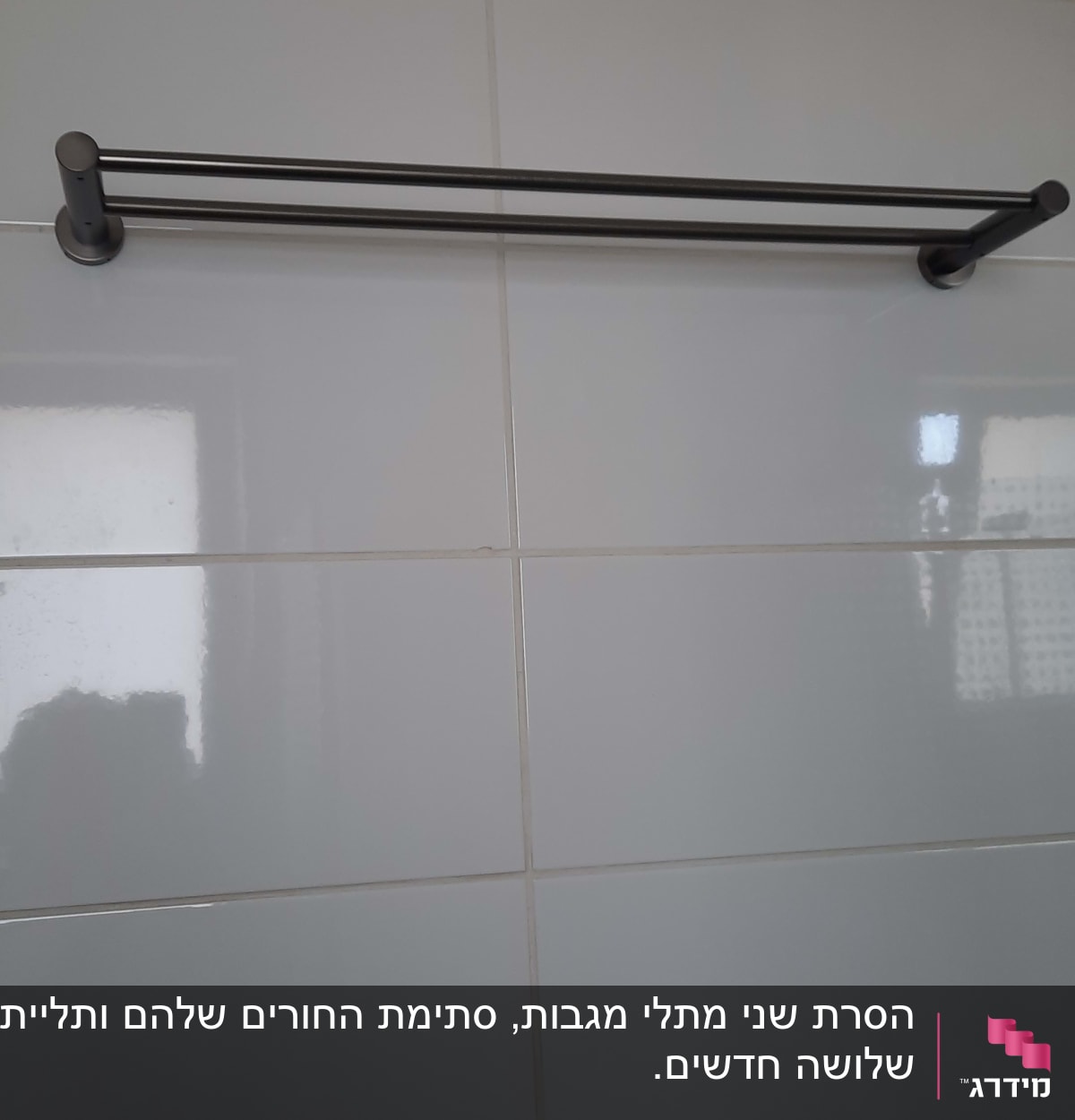 מוט מגבת מתכת מותקן על קיר אריחים